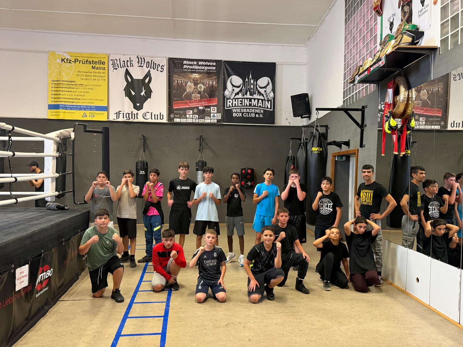 Jugendgruppe des Clubs posiert im Box-Gym vor dem Ring
